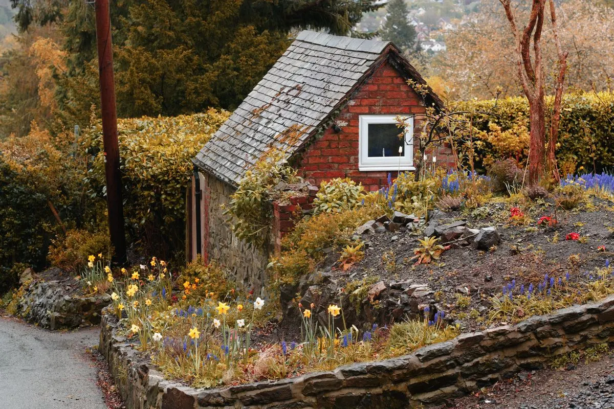 Brick cottage in England with spring flowers in the front garden