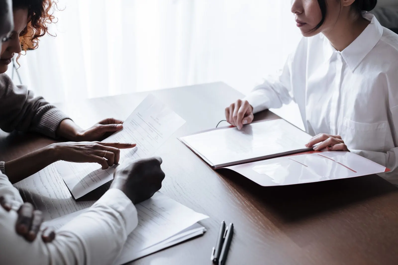 People reviewing documents together during a meeting at a table