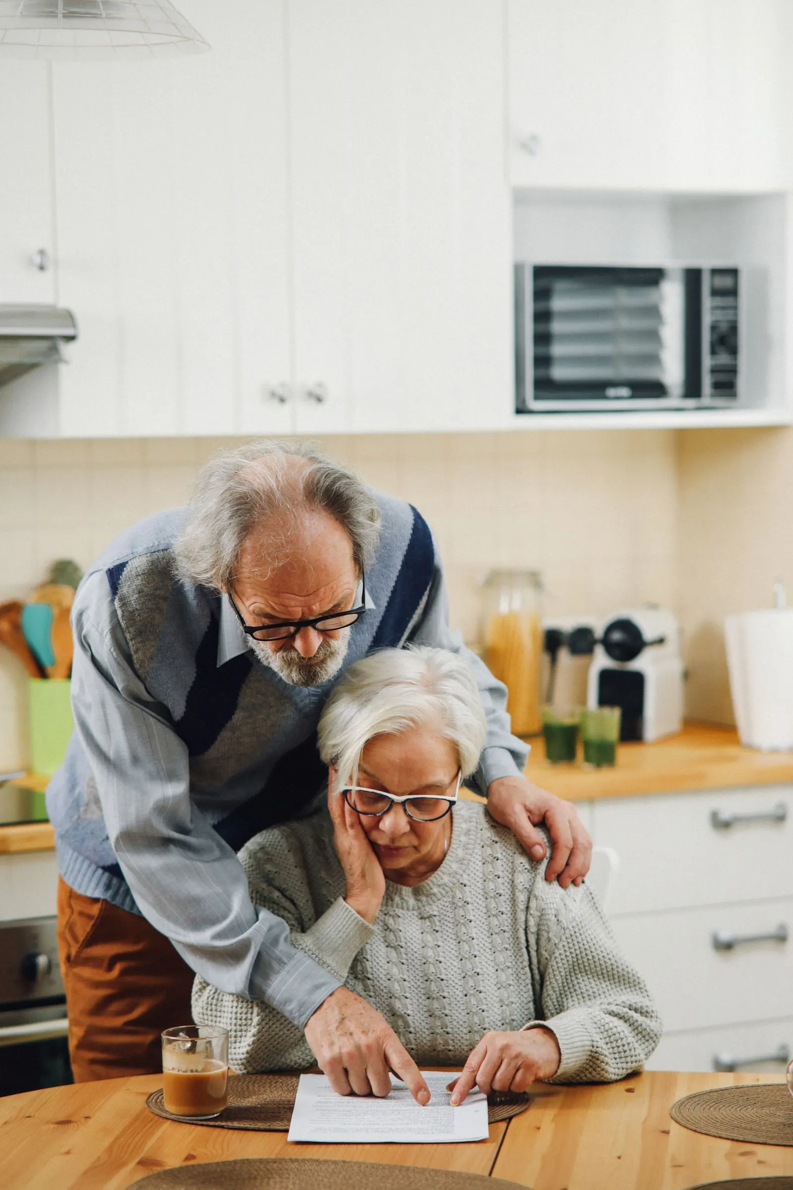 Older couple reading documents together at their kitchen table